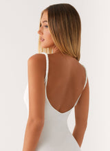 Détail du dos décolleté et bretelles fines de la robe blanche