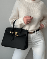 Sac noir porté avec pull blanc – contraste doux et élégant