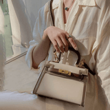 Gros plan du sac Gabi beige tenu à la main – finitions couture