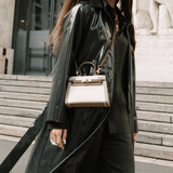 Sac Gabi porté à la main avec manteau foncé – contraste élégant