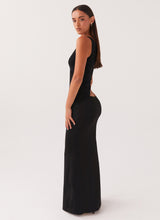 Robe noire à une épaule vue de profil, coupe fluide