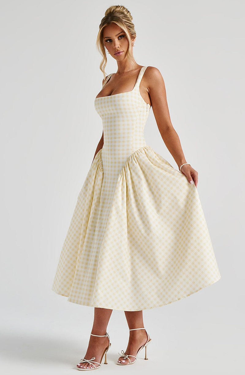 Modèle regardant vers le haut en robe vichy jaune – pose romantique