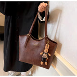 Sac à main femme marron classique en cuir, porté au quotidien