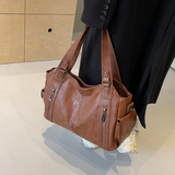 Grand sac à épaule marron femme posé sur table, cuir souple